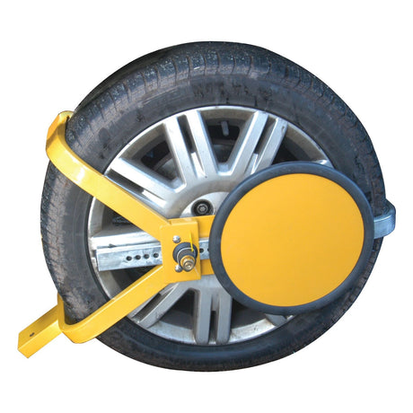 A car tire with a yellow Wheel Clamp 330 - 430mm (13 to 17'') from Sparex, Part No. S.13046, attached, preventing the vehicle from being moved.