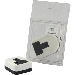 A white travel adapter with black prongs is displayed inside a clear plastic packaging with a labeled cardboard backing. Another identical travel adapter, which is compatible with the Sparex 13 amp Single Extension Lead Socket (Nylon) Agripak (Sparex Part No.S.24805), is placed in front of the packaging.
