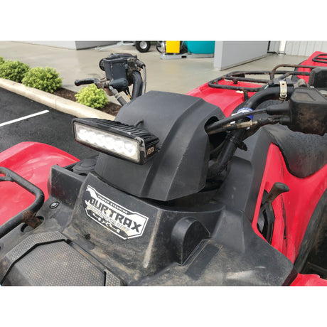 Close-up of an ATV's steering area featuring a mounted action camera, a Sparex LED Flat Work Light Bar measuring 165mm with an impressive 2800 Lumens raw output, and a SuperTrax sticker. The ATV has red body panels and is positioned near a curb and small bushes.