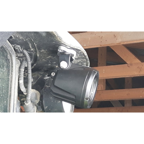 Close-up of a mounted black surveillance camera with visible wiring, installed on a structural beam, next to a Sparex LED Worklight Bracket, Fits S.130032 & S.130033 (Sparex Part No.S.156572).