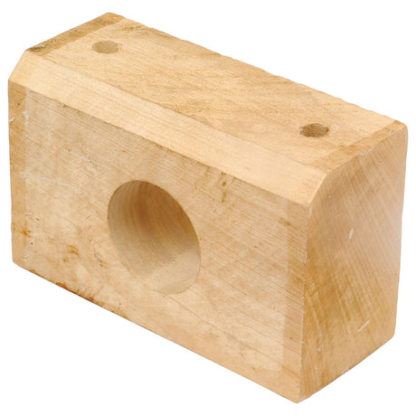 A rectangular wooden block with a circular hole through its center, reminiscent of the Sparex Wooden Roller Bearing Replacement for Twose (Sparex Part No. S.22781), and two small holes on the top surface.