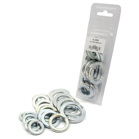 A variety of metal washers, including Sparex Imperial Spring Washers, are displayed. Some are scattered in front while others are packaged in a plastic container labeled "S.2286." Many of these washers adhere to the DIN 127B standard and feature a zinc-plated finish.