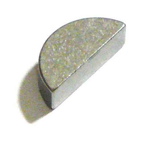 A gray, semicircular Sparex Imperial Woodruff Key 3/8'' x 1 3/8'' (DIN or Standard No. DIN 6888) is placed on a white surface, casting a faint shadow.