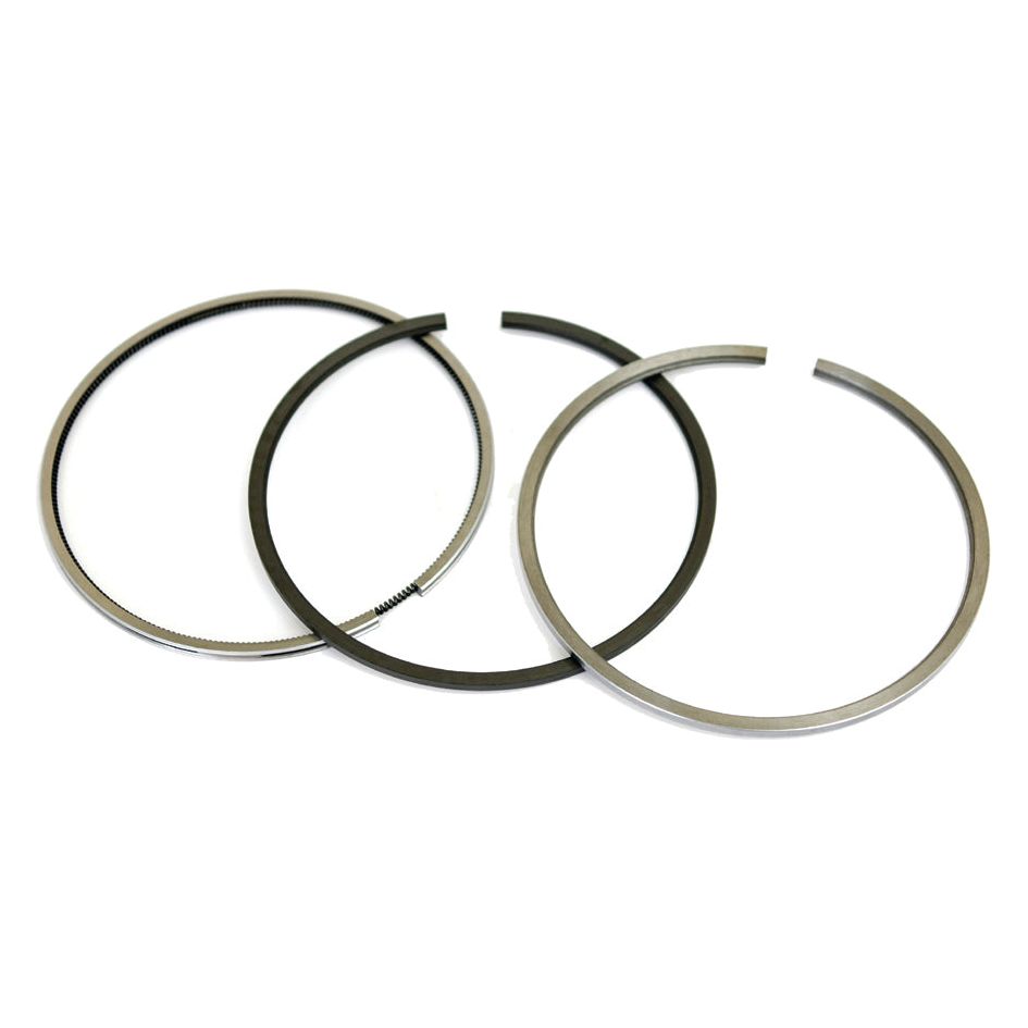 Three piston rings from the Sparex Piston Ring Set (Sparex Part No. S.30056), arranged side by side on a white background. One ring, part of the chrome-plated set, has slight grooves along its edge. The rings vary slightly in thickness.
