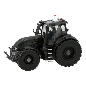 An AGCO scale model features a Valtra - VALTRA Q305 BLACK MATT (V42803500) tractor with large tires, a detailed cabin, and various mechanical components visible on its body.