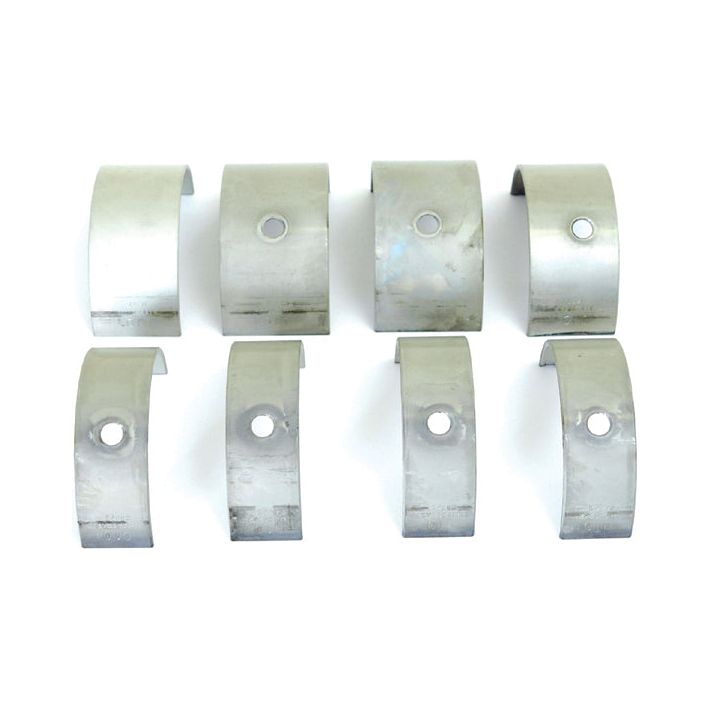 Eight metallic half-ring components with various surface finishes, arranged in two rows, resembling parts compatible with Massey Ferguson machinery and bearing the Sparex Part No. S.40332 (Main Bearing +0.010" / 0.25mm). Some pieces feature holes in the center.

