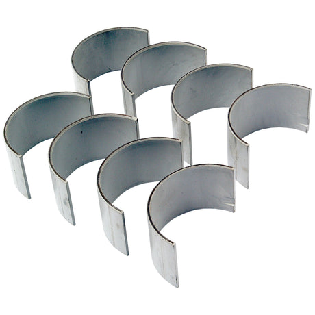 The Sparex Conrod Bearing +0.010'' (0.25mm) Set, Sparex Part No.S.57651, includes eight slightly curved metal engine bearings arranged in two neat rows, each featuring a smooth inner surface. These bearings are compatible with Ford/New Holland machinery and are built to the exacting standards you rely on from the Sparex brand.