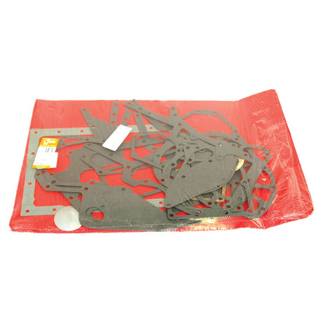 A collection of Sparex Bottom Gasket Sets (3 Cyl. D155, D179) laid out on a red plastic sheet, perfect for repairing your Case IH equipment.