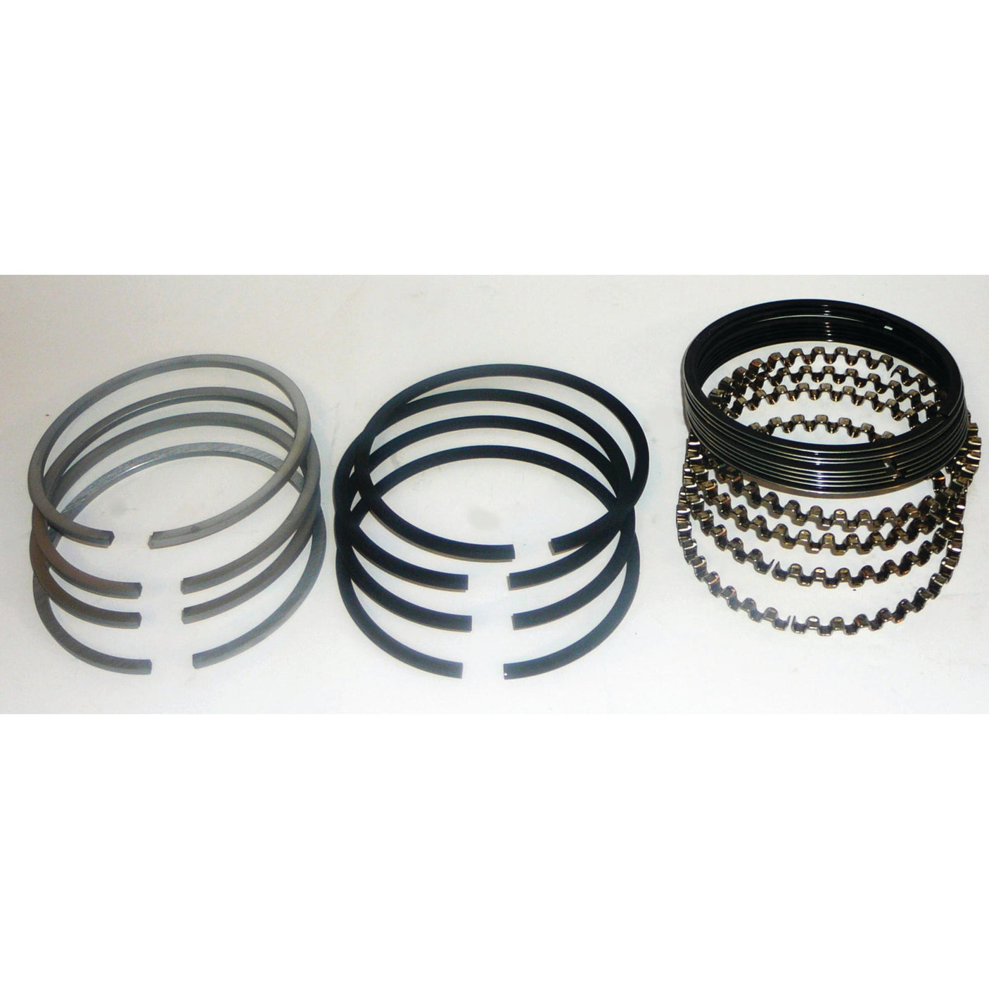 Three stacks of piston rings, identified as the Sparex Piston Ring Set (Part No. S.60853), are placed side by side against a plain background. The metallic rings, designed for compatibility with Ford / New Holland models, vary in design and shape.