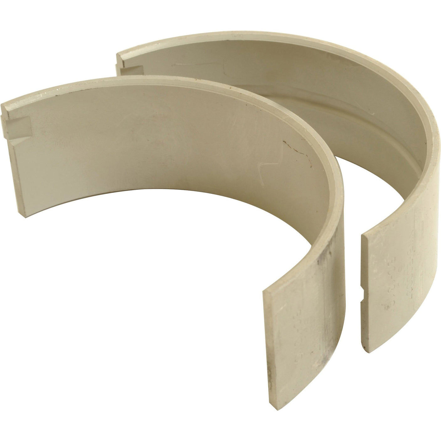 The Conrod Bearing Std. Pair (Sparex Part No. S.63389) features two beige semi-circular bearing shells with a smooth inner surface and a split design, positioned slightly apart, ideal for Massey Ferguson or Case IH machinery, available from Sparex.