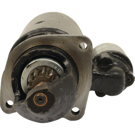 Close-up of the Starter Motor - 12V, 2.9Kw (Sparex) with a visible pinion gear and mounting bracket, showcasing its weathered and worn condition. This Sparex Part No.S.64051 demonstrates durability through years of use.