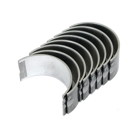 The Conrod Bearing Std. Set by Sparex (Part No. S.64099) consists of seven metal engine bearings, commonly utilized as tractor parts for Zetor models, featuring a semi-circular shape and arranged in a row.