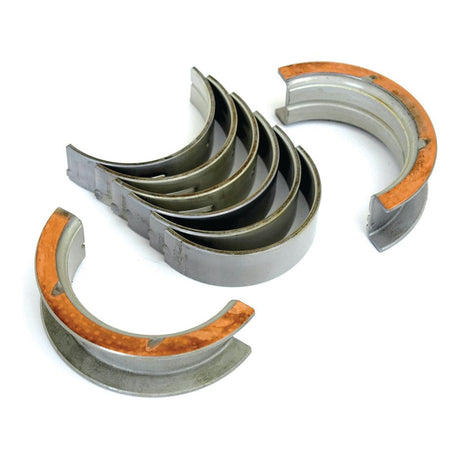 A set of large, curved metallic bearing shells and several separate bearing shells displaying their inner surfaces, perfect for Ford New Holland tractors—introducing the Main Bearing +0.020'' (0.50mm) (Set) by Sparex, Part No. S.65220.