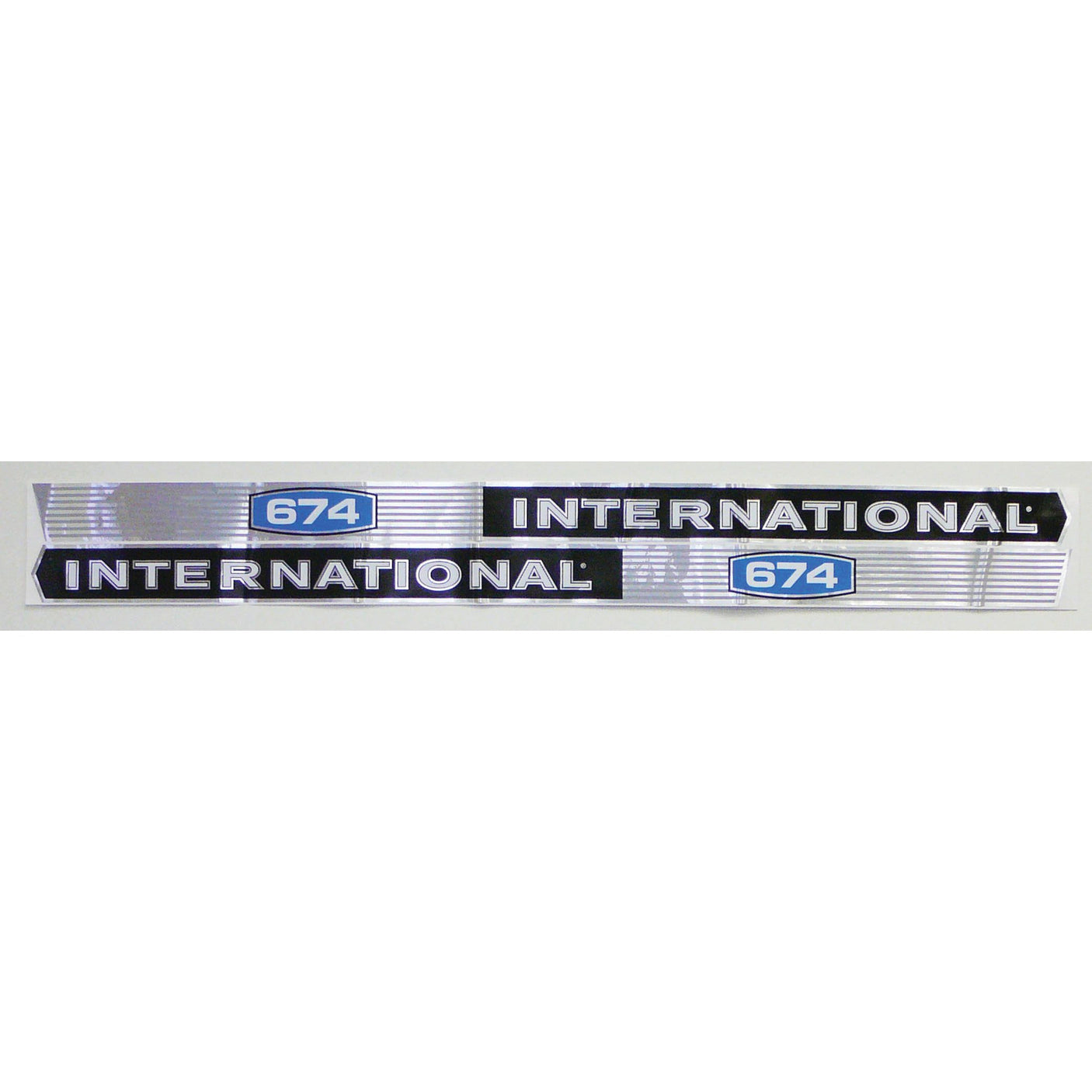 A metallic badge from the Decal Set - Case IH / International Harvester IH 674 | Sparex Part No.S.67754, featuring "INTERNATIONAL 674" in bold black letters with a blue and white "674" emblem on both ends, reminiscent of the classic International Harvester design. This authentic decal set by Sparex pays homage to the legacy of Case IH equipment.