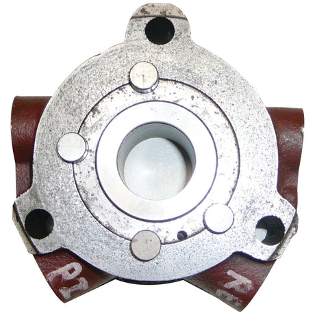 Close-up of a metallic mechanical part with brown accents, featuring several circular components and holes, possibly the Sparex Power Steering Valve Assembly (Sparex Part No. S.67889) for a Ford New Holland tractor.