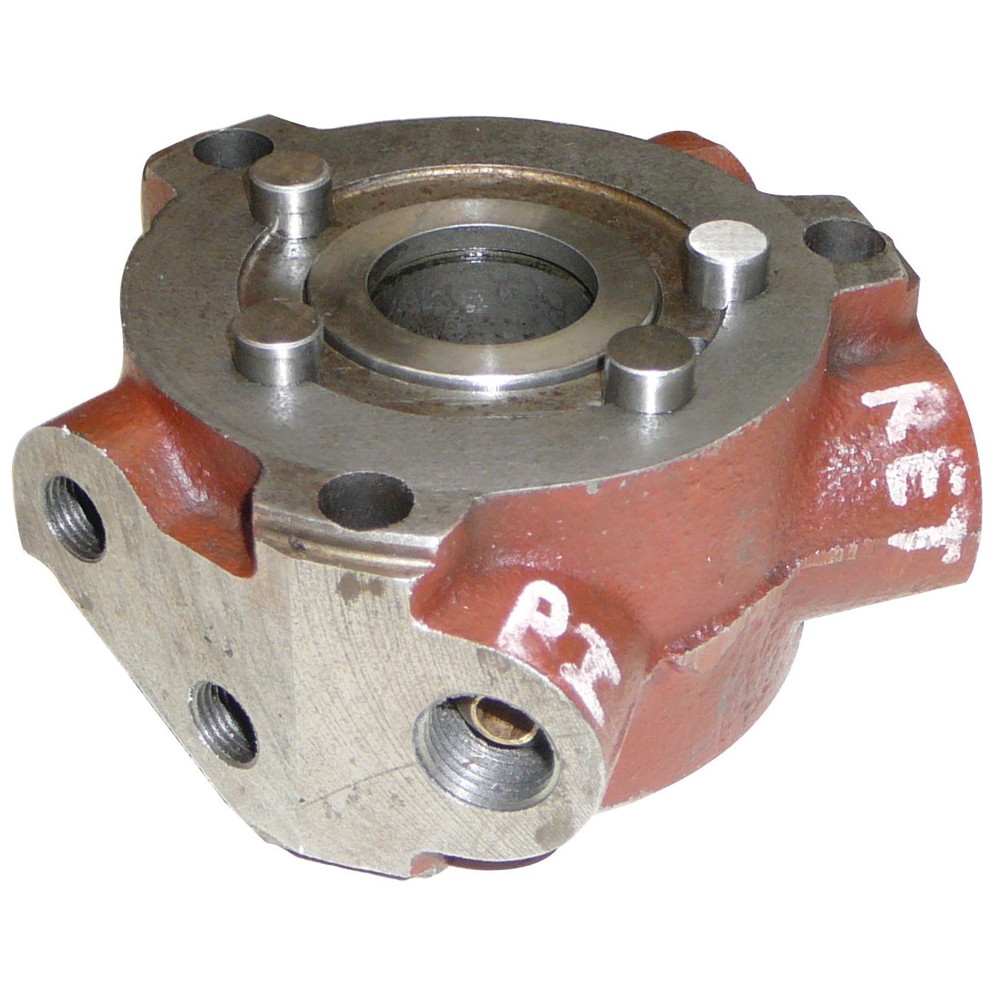 Image of a metal mechanical component with a cylindrical hole in the center and four mounting holes. Painted red with markings labeled "P2" and "KET," this part resembles the Power Steering Valve Assembly for Ford New Holland tractor parts, branded as Sparex with Part No. S.67889.