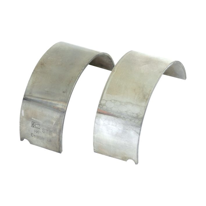 Two semi-circular metal pieces, identified as Conrod Bearing Std. Pair S.69955 from the Sparex brand, are placed upright against a white background. One piece appears more tarnished compared to the other.