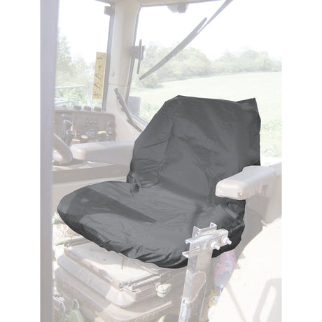 A Sparex Standard Seat Cover - Tractor & Plant (product code S.71719), featuring a grey waterproof design, is installed on the driver's seat inside a vehicle, with a scenic view of trees and a field visible through the window.