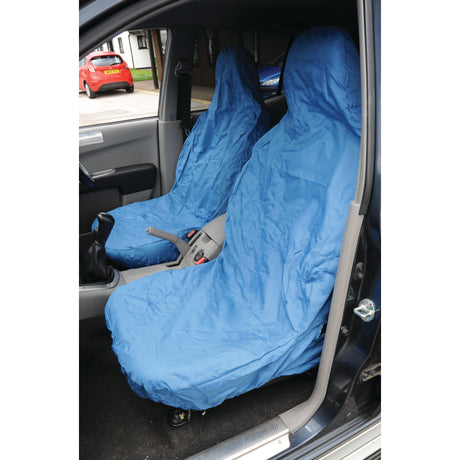 Two front car seats are covered with Sparex Front Large Seat Cover - Car & Van - Universal Fit (S.71859) in blue and waterproof material. The car door is open, revealing part of the exterior.