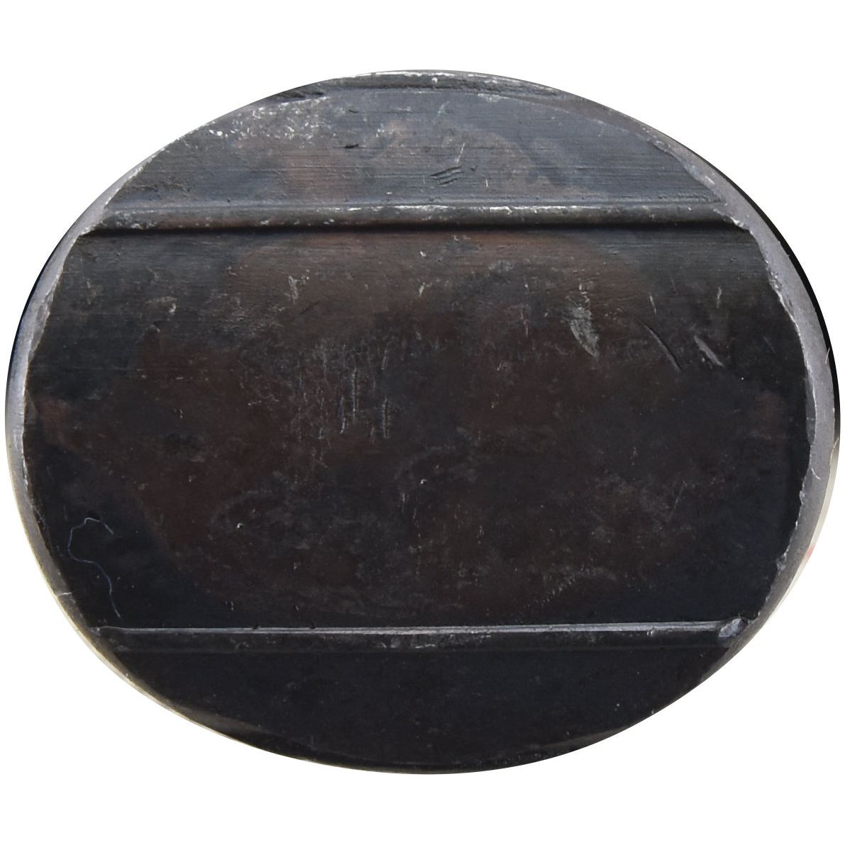 A round black metal object with ridges, exhibiting signs of wear and scratches, reminiscent of a well-used Sparex Oval Head Double Nib Bolt With Nut (TO2E) - M12 x 64mm, Tensile Strength 10.9 (Sparex Part No. S.72421).