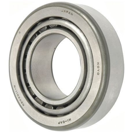 Close-up of a metal ball bearing labeled "KOYO" and "JAPAN," featuring an inner and outer ring with ball grooves, typical of a high-quality Sparex Taper Roller Bearing (M802048/M802011) - S.7786.