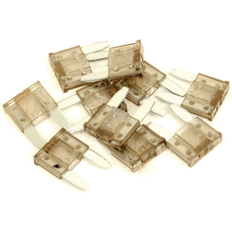 A collection of several clear blade fuses scattered on a white surface resembles the organized assortment often found in a Sparex Mini Blade Fuses Agripak 2.0 Amps 10 pcs. (Sparex Part No.S.79270) toolkit.