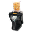 The AG-MAC Grain Moisture Tester - S.28721 by Sparex, featuring a digital display and a clear container filled with corn kernels on top, is ideal for precise moisture readings. Its design provides essential moisture information critical for storage and quality control.