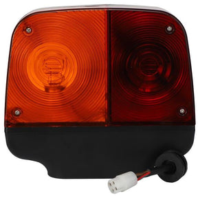 Close-up of the Massey Ferguson - Combination Lamp - 6256747M91 by AGCO, featuring one amber and one red lens, along with an attached electrical connector with exposed wires, commonly used in Massey Ferguson tractor parts.