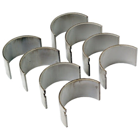 Image of eight semi-circular Conrod Bearing +0.030'' (0.75mm) Set | Sparex Part No.S.57653 from Sparex, often used in International Harvester and Ford / New Holland machinery, arranged in two rows of four.