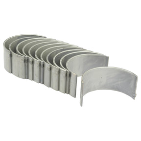 A stack of Conrod Bearing Std. Sets (Sparex Part No. S.40327), arranged in a slightly curved, nested formation, each piece featuring a smooth surface and uniform width, ideal for inclusion in a Perkins Build List or other related product catalogs from Sparex.