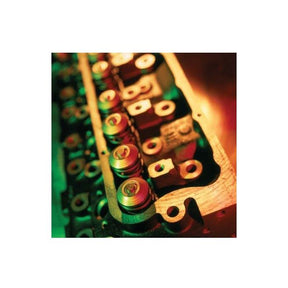 Close-up of an AGCO Cylinder Head for Massey Ferguson (4222810M91) with multiple valves and springs, illuminated by a mix of red and green lighting.