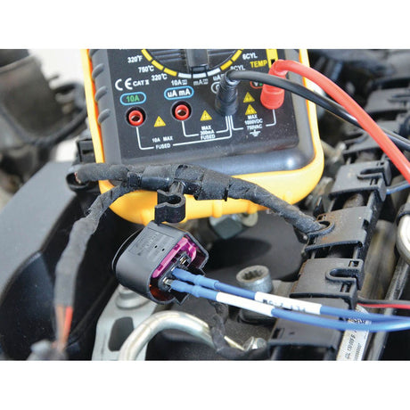 A close-up of the Sparex Diagnostic test lead set - S.151759 connected to electrical wires in a vehicle engine, showing an automotive diagnostics test in progress with precise resistance adjustment.
