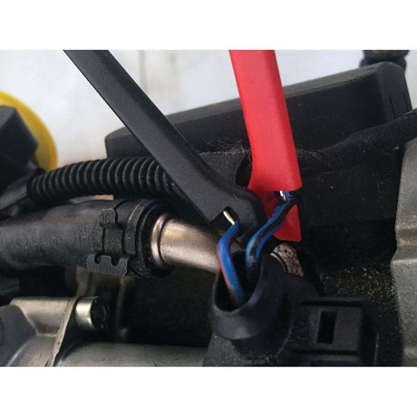 Close-up view of electrical wires and components in an automotive setting, showcasing the connection of blue wires with black and red plastic covers, using the Sparex Diagnostic Test Lead Set (S.151759), essential for precise automotive diagnostics.
