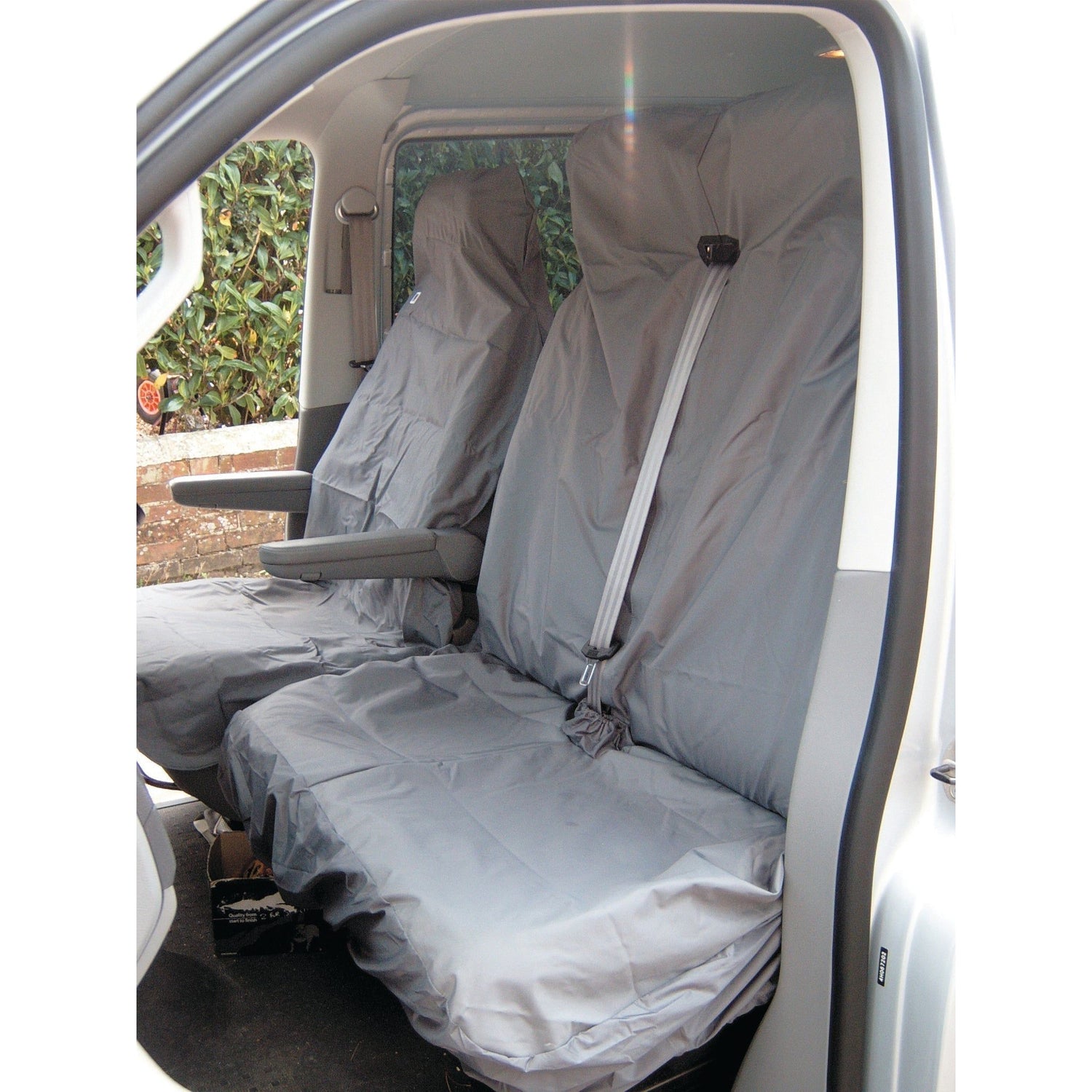 The double front seats of the vehicle are equipped with Sparex Double Passenger Seat Covers (S.71715), which feature a universal fit for vans. These gray, waterproof protective covers have seat belts fastened over them and an armrest on the left seat.
