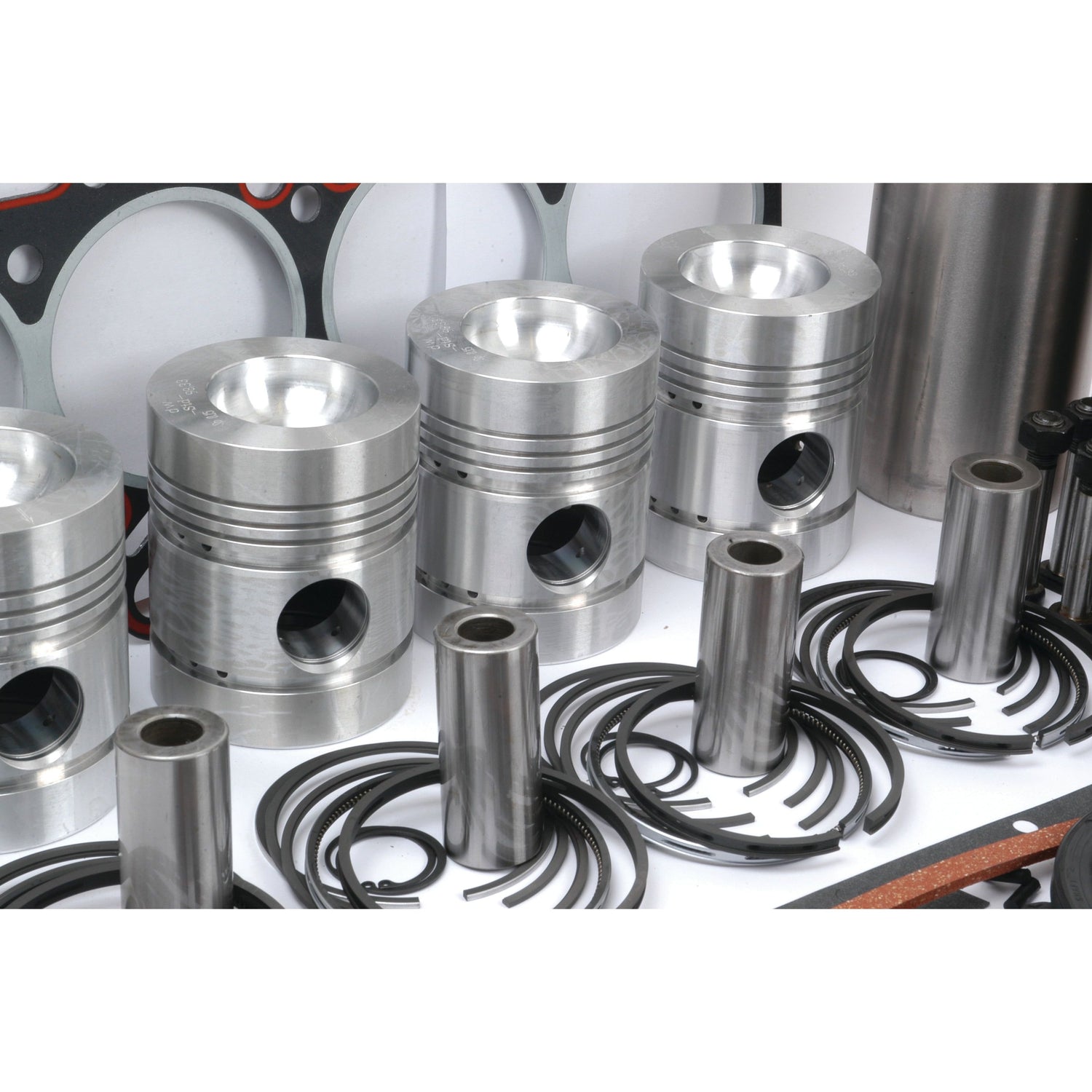 Several metallic pistons, piston rings, and other engine components from the Sparex Engine Overhaul Kit without Valve Train (Finished), Part No. S.41907, are arranged on a white surface.