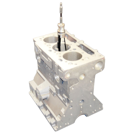 A metal engine block with internal components, featuring two large circular openings and a slender vertical rod extending from one of the openings, set against a plain background, showcases the ideal setup for using the Sparex HONE 3 LEG CYLINDER (Sparex Part No. S.26414) to efficiently de-glaze engine cylinders.