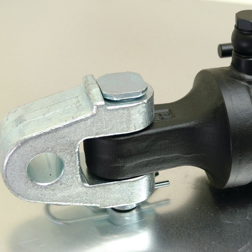 Close-up of the Sparex Hydraulic Top Link (Cat.3/3) Knuckle and Q.R CBM Hook, a metal mechanical component with an 80mm cylinder bore and a minimum length of 610mm. The component features a U-shaped bracket attached to a cylindrical part, secured with bolts and a pin. Resembling parts of a tractor implement, this hydraulic cylinder component (Sparex Part No.S.399811) is placed on a reflective surface.