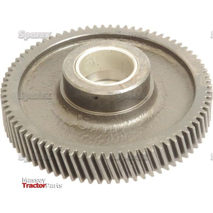 Close-up image of the Idler Gear - S.59079 by Sparex, featuring 77 teeth around the edge, an outer diameter (OD) of 121.6mm, and a central bearing, used in machinery. Logos for Sparex and Massey Tractor Parts are visible on the gear's width, which is 20mm.
