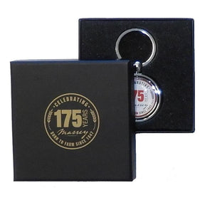 AGCO's limited edition Massey Ferguson steel key ring, product X993342212000, comes in a sleek black gift box with "Celebrating 175 Years" and "Born to Farm Since 1847" elegantly inscribed on the lid.