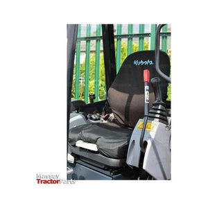 Close-up of a tractor seat and control lever with "Kubota" embroidered on the seat back, partially covered by a black Sparex Seat Cover (Seat Type - Mini Digger) - S.127941. The background shows a green fence and some blurred foliage. Image has "Massey Tractor Parts" watermark.
