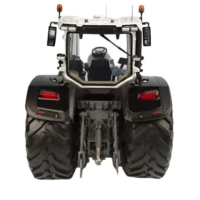 Rear view of a 1:32 scale model MF 8S.285 Black Version tractor (X993042106341) by AGCO, showcasing large tires, rear lights, and hydraulic arms. The Massey Ferguson tractor features a cab with a steering wheel and mirrors. The background is plain and neutral.