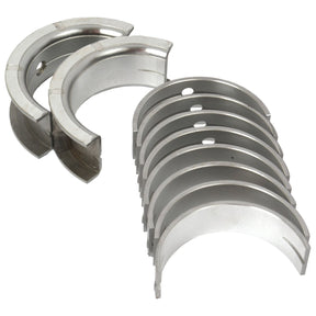 A set of Sparex Main Bearings +0.010'' (0.25mm) (Sparex Part No.S.57660), compatible with Case IH machinery, arranged in two groups, each semi-circular bearing featuring holes for mounting.