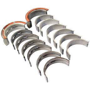 The Sparex Main Bearing +0.020'' (0.50mm) (Set), Part No. S.66533, includes a set of metal half-shell main bearings arranged in two rows, with one bearing featuring a rust-colored coating on its inner edge, suitable for use in Case IH and Ford / New Holland machinery.