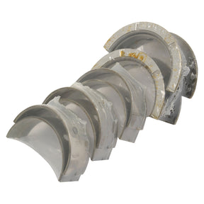 A set of six curved, transparent plastic pieces with metallic edges, arranged in a row, showing some signs of wear. This set resembles components you might find in machinery like the Sparex Main Bearing +0.020'' (0.50mm) Set (Part No. S.75844).