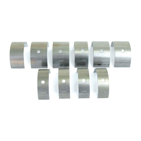 Ten metal bearing shells arranged in two rows, each with a hole near one end and various imprinted markings, suitable for use in Massey Ferguson or Landini machinery. Available as Sparex Main Bearing Std. (Set) | Sparex Part No.S.40335.