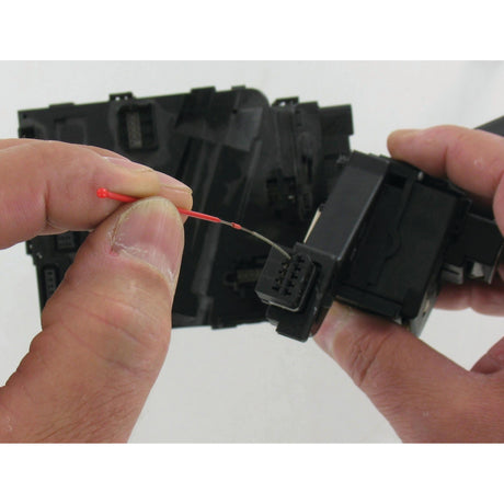 Hands holding and connecting an electronic connector with a small red tool inserted into the sockets, carefully using Sparex Super hard Diamond-Coated Round Micro Files - S.151751 to ensure precision.