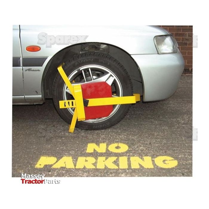 A car tire is locked with a Wheel Clamp 330 - 430mm (13 to 17'') by Sparex, Part No.S.13046. The ground in front of the tire is painted with the words "NO PARKING" in yellow.