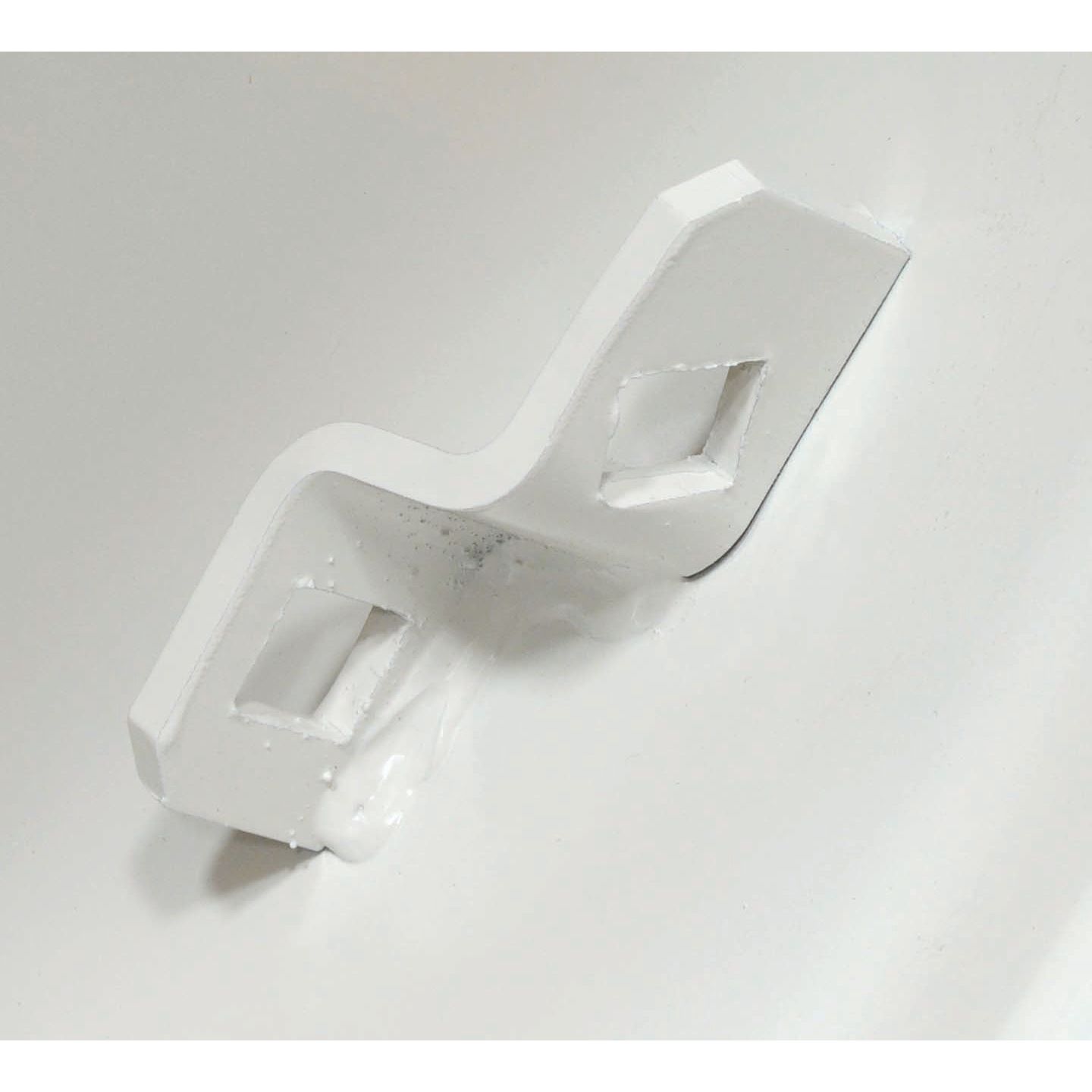 Close-up image of a white, S-shaped metal bracket with two square cut-outs mounted on a white surface, showcasing the versatility of Sparex's Wheel Rim (S.60114) in Rim Size 13 x 28".